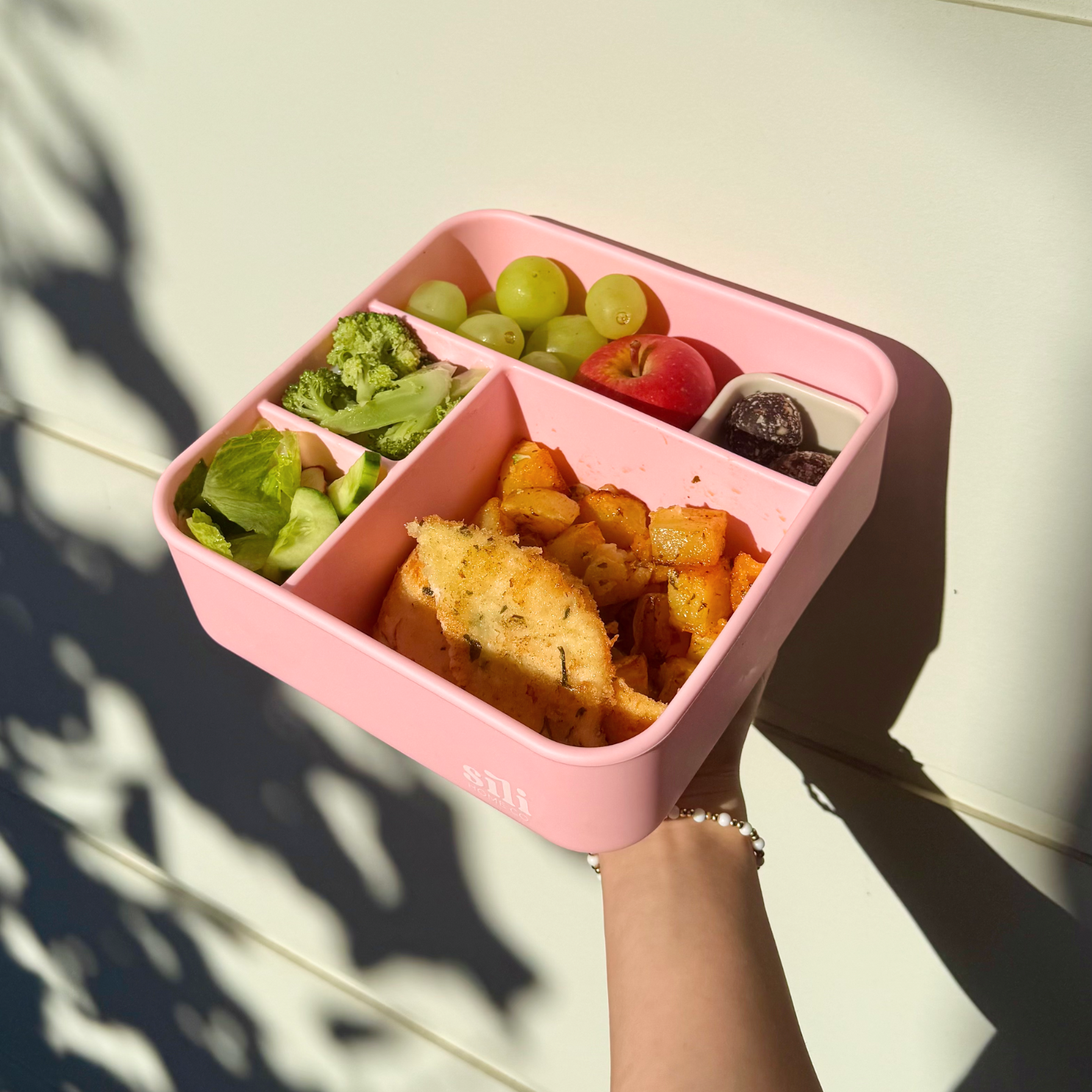 pink silicone compartment lunch box filled with food